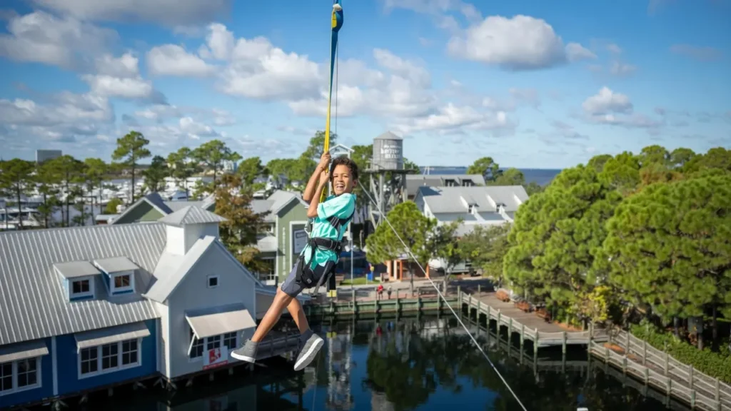 kid on a zip line at baytowne adventure zone in baytowne wharf village
